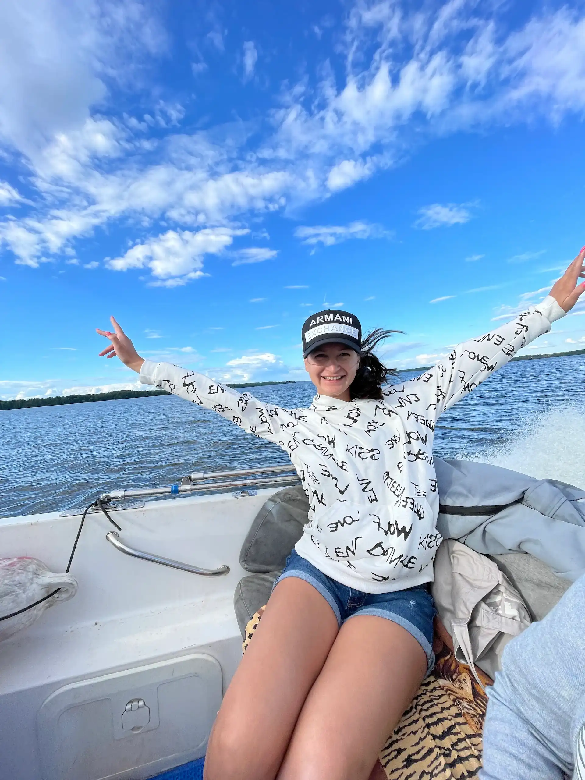 жизнерадостная девушка позирует на камеру, катаясь на катере по реке Волга